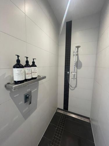a bathroom with a shower and two bottles of alcohol at Titoki Grove in Cambridge