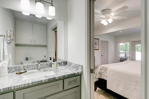 baño con lavabo, cama y espejo en Kingwood Cottage - 10 mins from IAH - Lake Front, en Humble