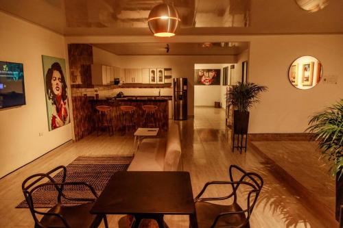 Casa Centro Guaduas في غوادواس: غرفة معيشة مع طاولات وكراسي ومطبخ