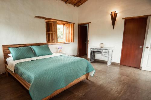 1 dormitorio con cama, mesa y ventana en Casa Primitivo, en Barichara
