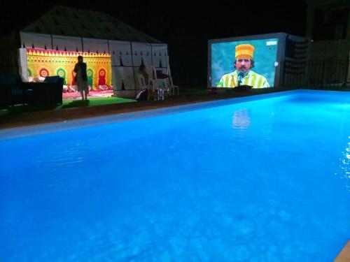 un hombre en una pantalla junto a una piscina en American Farm Villa Grand Casablanca/El Jadida 