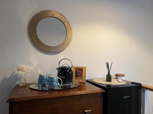 a wooden dresser with a mirror on the wall at The Snug@Bournville in Birmingham