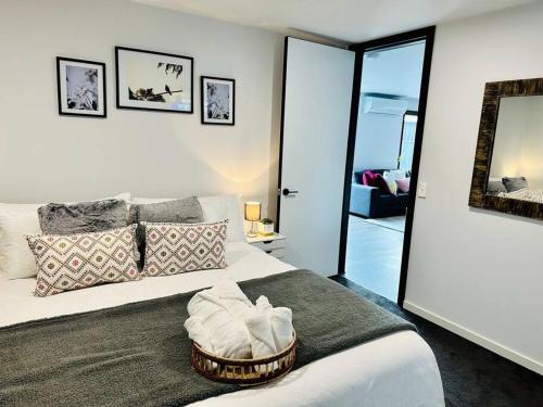 1 dormitorio con cama blanca y espejo en Spacious modern family home, en Pakenham