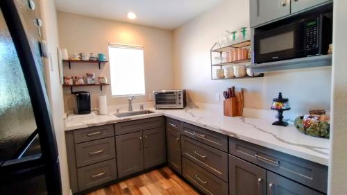 a kitchen with a sink and a microwave at Falcon Cottage in Pahrump