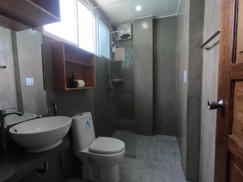 a bathroom with a toilet and a sink and a shower at The Beach House in El Nido