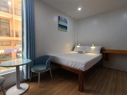 a bedroom with a bed and a table and a window at The Beach House in El Nido