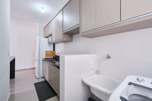 uma casa de banho com armários brancos e um lavatório em 2 QUARTOS com Churrasqueira na Varanda, Piscina, Garagem interna, WiFi 500mbps, Ar Condicionado e Telas de Proteção em Ubatuba