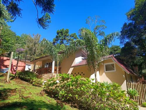 a house in the woods with a fence at Pousada Villa Bergamin in Monte Verde