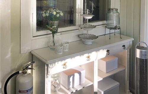 einen weißen Konsole-Tisch mit Blumen und einem Fenster in der Unterkunft Awesome Home In Linkping With Wifi in Linköping