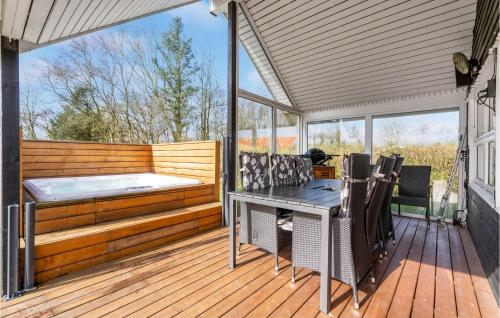 une terrasse avec un bain à remous, une table et des chaises dans l'établissement Nice Home In Hemmet With Kitchen, à Hemmet