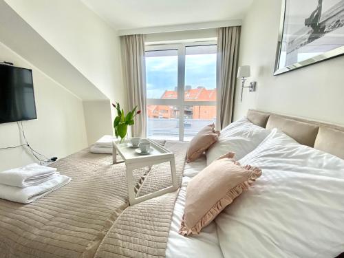 a bedroom with a bed with a television and a table at Apartament Szafarnia DeLux in Gdańsk