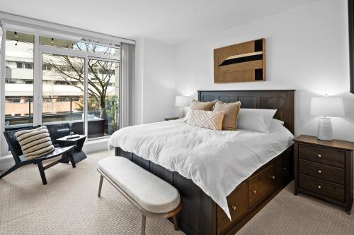 ein Schlafzimmer mit einem Bett, einem Stuhl und einem Fenster in der Unterkunft Falls Pond Retreat by Iris Properties! in Victoria