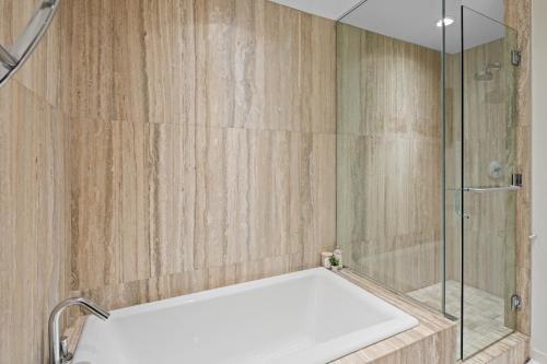 ein Badezimmer mit einer Dusche und einer weißen Badewanne in der Unterkunft Falls Pond Retreat by Iris Properties! in Victoria