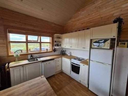 een keuken met witte apparatuur en een houten plafond bij Aurora borealis in the middle of Golden circle in Kerhraun