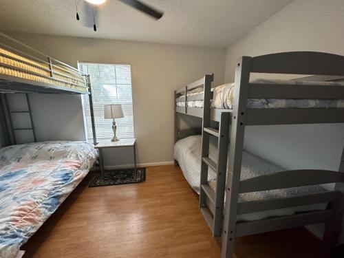a bedroom with two bunk beds and a window at Beautiful House Sleeps 12 - Hot Tub - Walk to Beach in Panama City Beach