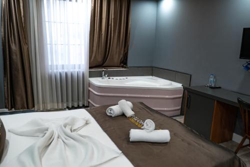 a bathroom with a bed with towels and a bath tub at Eva Hotel in Antalya