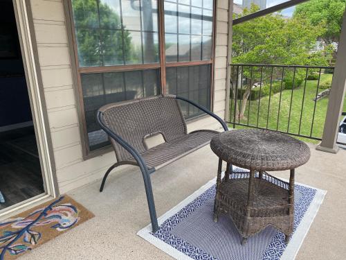 a wicker chair and a table on a porch at Lovely 1 bed condo near Lake Ray Hubbard in Garland