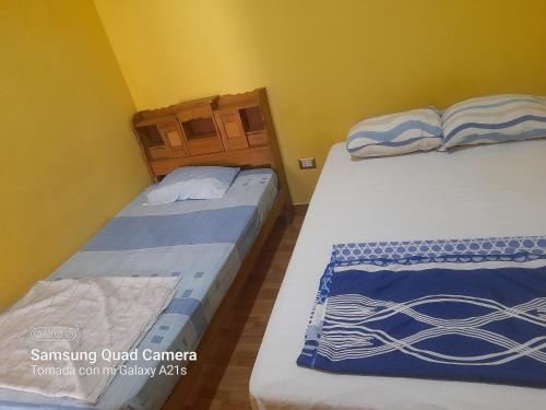 twee bedden in een kamer met gele muren bij Kely1 Primer Piso in Lima