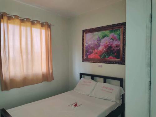 1 dormitorio con 1 cama con una pintura en la pared en WJV INN CASUNTINGAN, en Mandaue