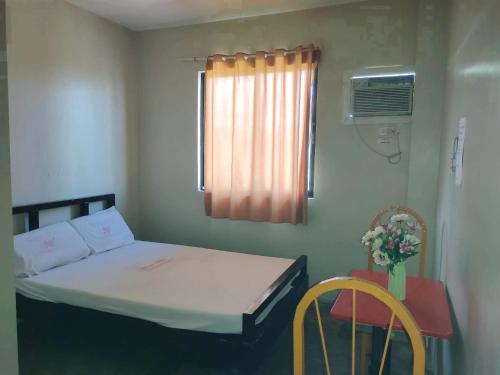 a small room with a bed and a table and chairs at WJV INN CASUNTINGAN in Mandaue City