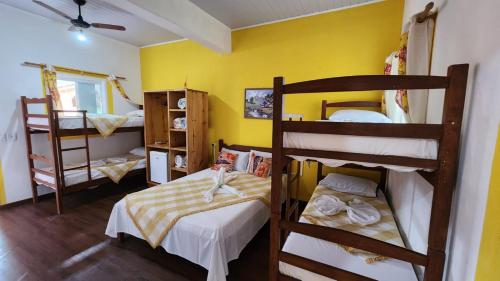 2 literas en una habitación con paredes amarillas en Pousada Caminho da Serra Paraty, en Paraty