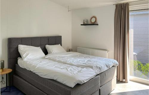 Una cama con sábanas blancas y almohadas en un dormitorio en Vakantiepark De Zeeuwse Parel, en Scherpenisse