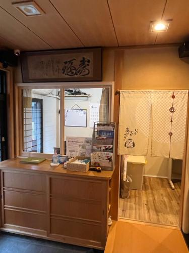 Zimmer mit einem Schreibtisch und einem Fenster mit einem Schreibtisch an der Wand in der Unterkunft 雅 in Nishinotōindōri