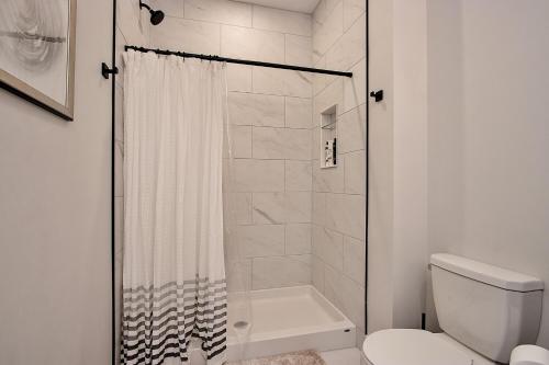 uma casa de banho branca com um chuveiro e um WC. em The National on Queen em Saint Marys
