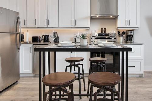 a kitchen with a counter with stools and a refrigerator at The National on Queen in Saint Marys
