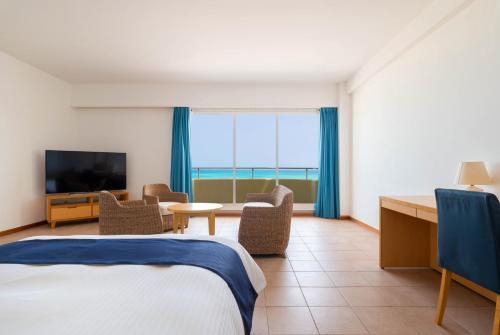 a hotel room with a bed and a television at EN RESORT Kumejima EEF Beach Hotel in Kumejima