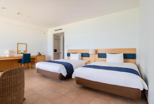 a hotel room with two beds and a desk at EN RESORT Kumejima EEF Beach Hotel in Kumejima