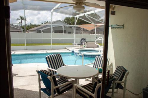 a patio with a table and chairs next to a pool at Florida Escape in Orlando