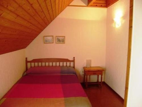 une chambre avec un lit et un plafond en bois dans l'établissement Appartement T3 chaleureux, 7 pers, cheminée, animaux admis, WiFi, proche commerces - FR-1-402-87, à Esquièze - Sère