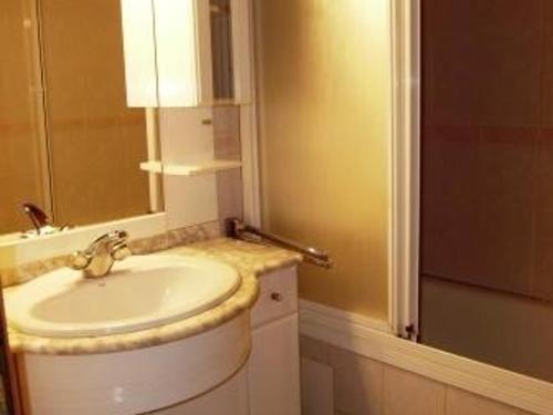 une salle de bain avec un lavabo et un miroir dans l'établissement Appartement T3 chaleureux, 7 pers, cheminée, animaux admis, WiFi, proche commerces - FR-1-402-87, à Esquièze - Sère
