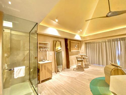a living room with a glass shower in a room at Hotel Shibari - Restaurant & Cenote Club in Tulum