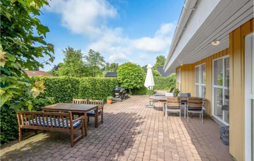a patio with tables and chairs and a umbrella at Holiday Home Rønnebærvænget Hejls V in Hejls