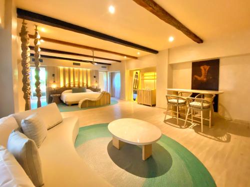 a living room with a couch and a bed and a table at Hotel Shibari - Restaurant & Cenote Club in Tulum
