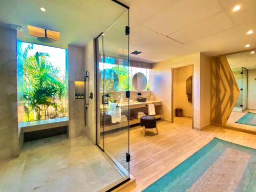 a bathroom with a glass shower and a desk at Hotel Shibari - Restaurant & Cenote Club in Tulum