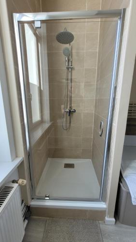 una doccia con porta in vetro in bagno di Le Lumia a Saint-Omer