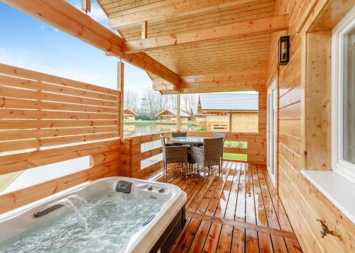 a jacuzzi tub on a wooden deck at Holly Tree Lodges in York