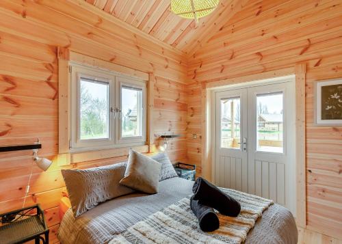 a bedroom with a bed in a wooden cabin at Holly Tree Lodges in York