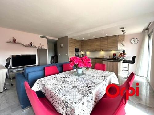 une table de salle à manger avec un canapé bleu et des chaises rouges dans l'établissement Appartement lumineux proche plages et centre-ville avec clim, balcons et parking inclus - FR-1-647-18, à Menton