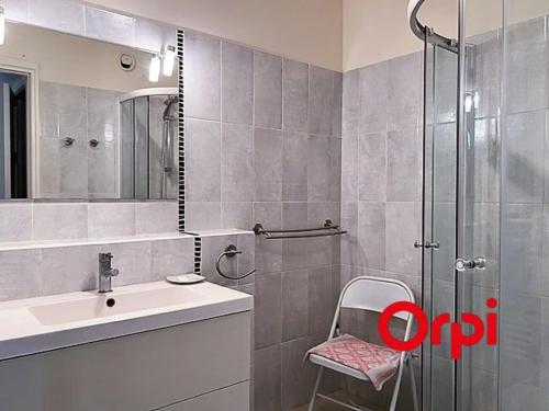 La salle de bains est pourvue d'une douche, d'un lavabo et d'une chaise. dans l'établissement Appartement lumineux proche plages et centre-ville avec clim, balcons et parking inclus - FR-1-647-18, à Menton
