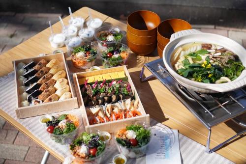una mesa con muchos tipos diferentes de comida en ella en Roots inawashiro Lake Area en Sekiwaki