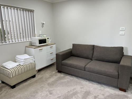 a living room with a couch and a microwave at Guest Suite - Cosy place in the Wattle Downs in Auckland