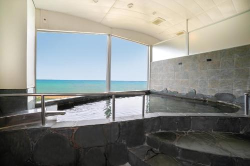 a hot tub with a view of the ocean at EN RESORT Kumejima EEF Beach Hotel in Kumejima