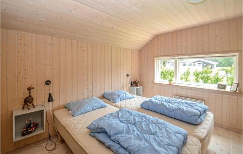 2 camas individuales en una habitación con ventana en Gorgeous Home In Vggerlse With Sauna, en Bøtø By