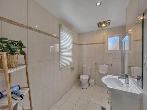 La salle de bains blanche est pourvue d'un lavabo et de toilettes. dans l'établissement Bright 3-bedroom apartment - Central Armidale, à Armidale