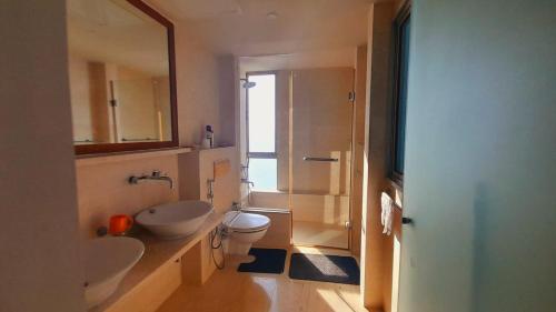 ein Badezimmer mit zwei Waschbecken, einem WC und einer Dusche in der Unterkunft LAKNA HOUSE in Colombo