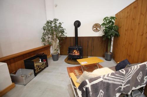 a living room with a wood burning stove in the corner at Roots inawashiro Lake Area in Sekiwaki